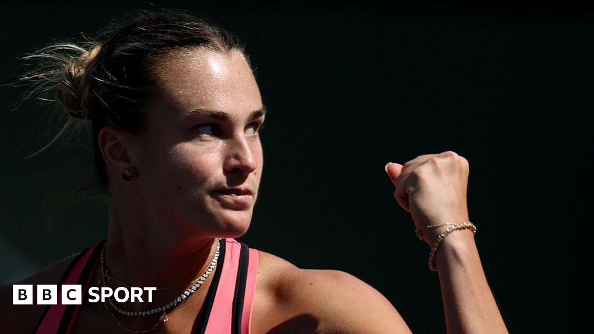 Close-up of Aryna Sabalenka who is raising her fist to celebrate winning a point.