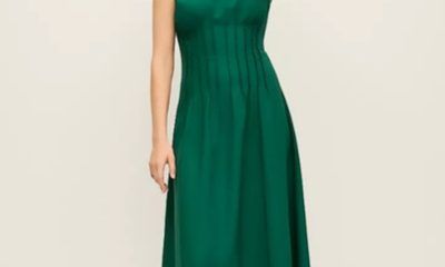 A woman wearing a green sleeveless midi dress