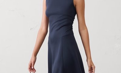 A woman wearing a sleeveless navy dress