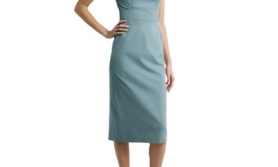 A woman wearing a light green sheath dress and black heels