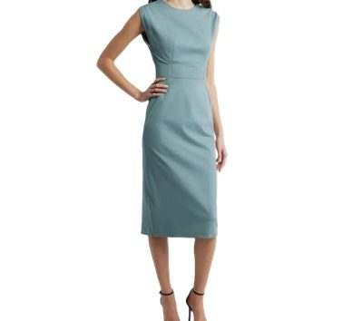 A woman wearing a light green sheath dress and black heels