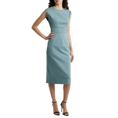 A woman wearing a light green sheath dress and black heels