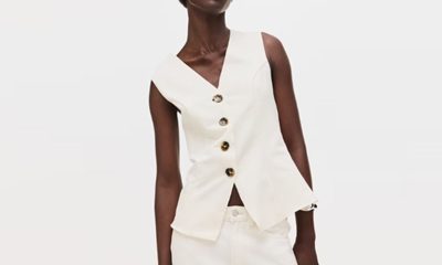 A woman wearing a cream-colored vest and matching pants