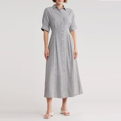 A woman wearing a black-and-white striped midi shirtdress and white sandals