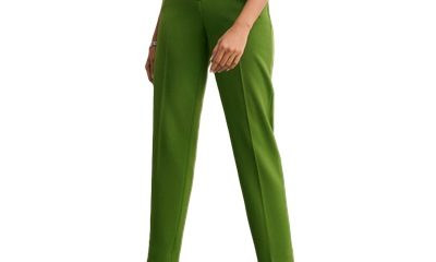 A woman wearing a black top, black slingbacks, and green pants