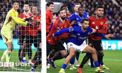 Iliman Ndiaye of Everton holds back Bruno Fernandes and Casemiro of Manchester United as players jostle at a corner kick