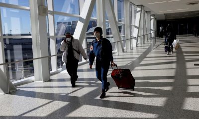 Air travellers wearing a protective face masks, amid the coronavirus disease (COVID-19) pandemic, at JFK International airport in New York