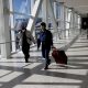 Air travellers wearing a protective face masks, amid the coronavirus disease (COVID-19) pandemic, at JFK International airport in New York