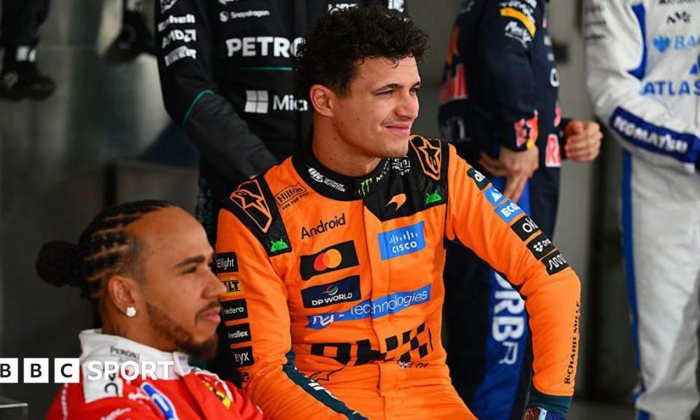Lewis Hamilton, wearing his red Ferrari suit and Lando Norris, wearing his papaya Mclaren suit, pose during the F1 2026 photocall in Bahrain