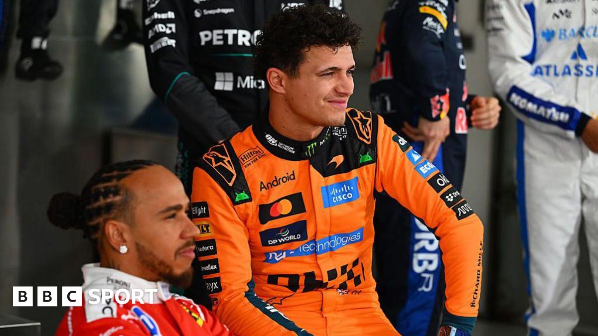 Lewis Hamilton, wearing his red Ferrari suit and Lando Norris, wearing his papaya Mclaren suit, pose during the F1 2026 photocall in Bahrain