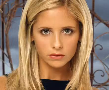 Sarah Michelle Gellar standing in front of an iron gate