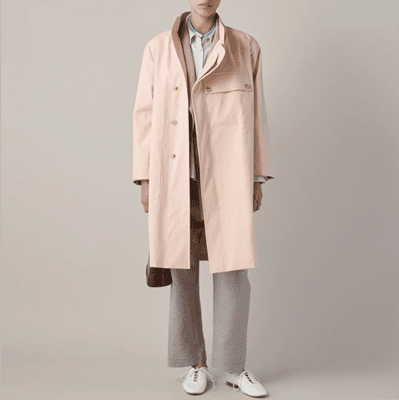 woman wears pale pink trench rain coat with beige slacks and white shoes