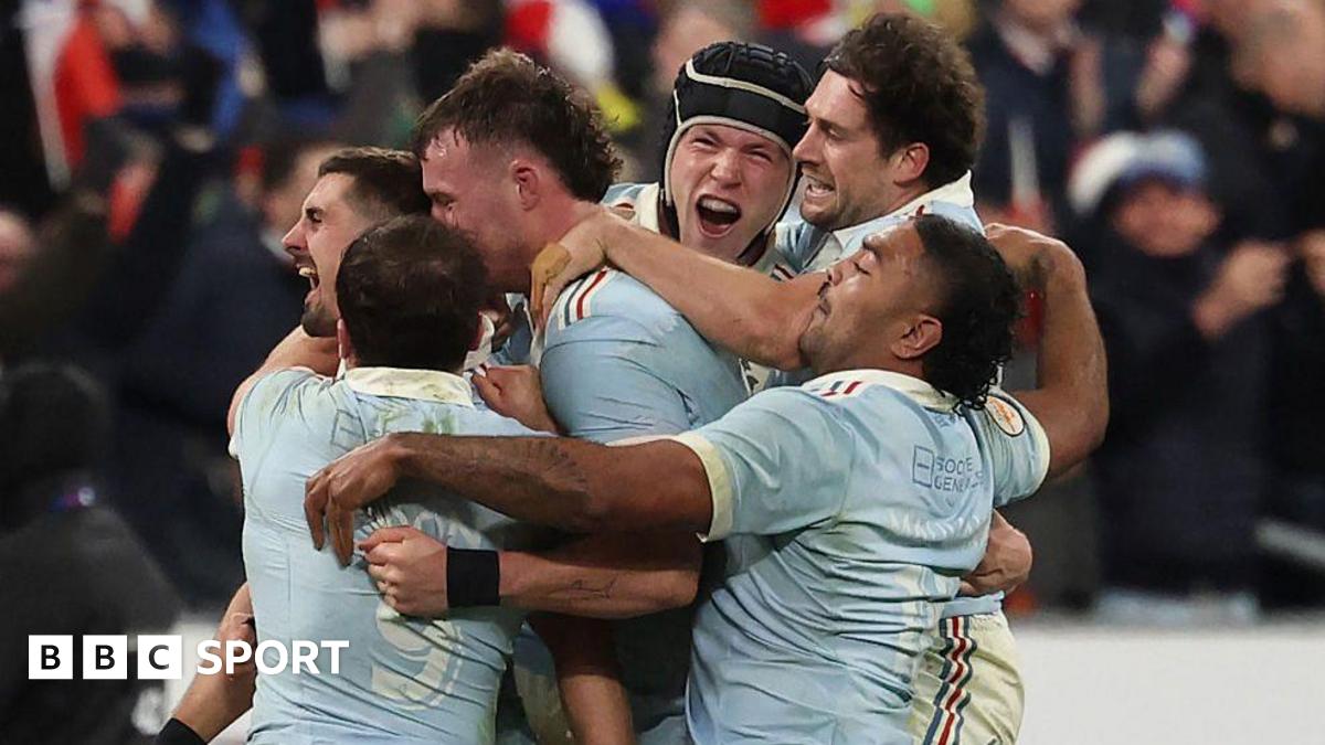 Thomas Ramos is mobbed by his France team-mates after landing the final kick to claim victory