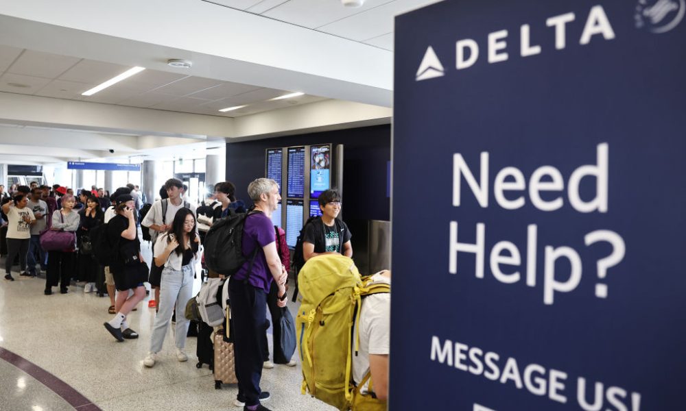 Air travellers wearing protective face masks, amid the coronavirus disease (COVID-19) pandemic, walk at JetBlue Terminal 5 at JFK International airport in New York, U.S., November 16, 2021.