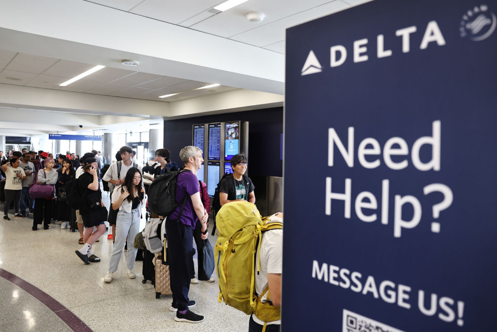 Air travellers wearing protective face masks, amid the coronavirus disease (COVID-19) pandemic, walk at JetBlue Terminal 5 at JFK International airport in New York, U.S., November 16, 2021.