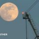 photo of the full moon on Tuesday morning rising next to a crane