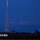 Artemis II rocket on the launch pad in Cape Canaveral with a full, bright and orange Moon rising in the sky next to it