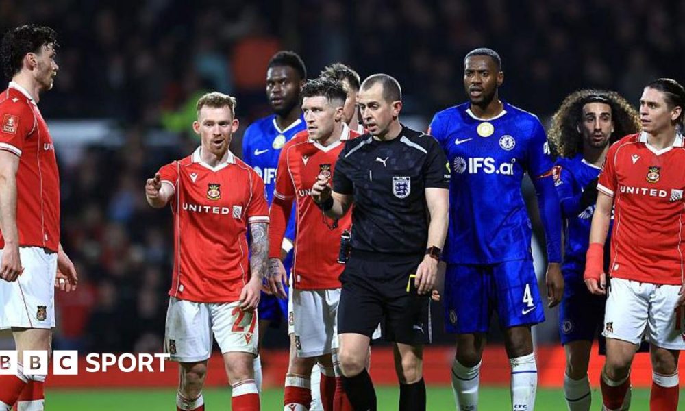 Lewis O'Brien of Wrexham speaks to Referee Peter Bankes as a VAR review takes place
