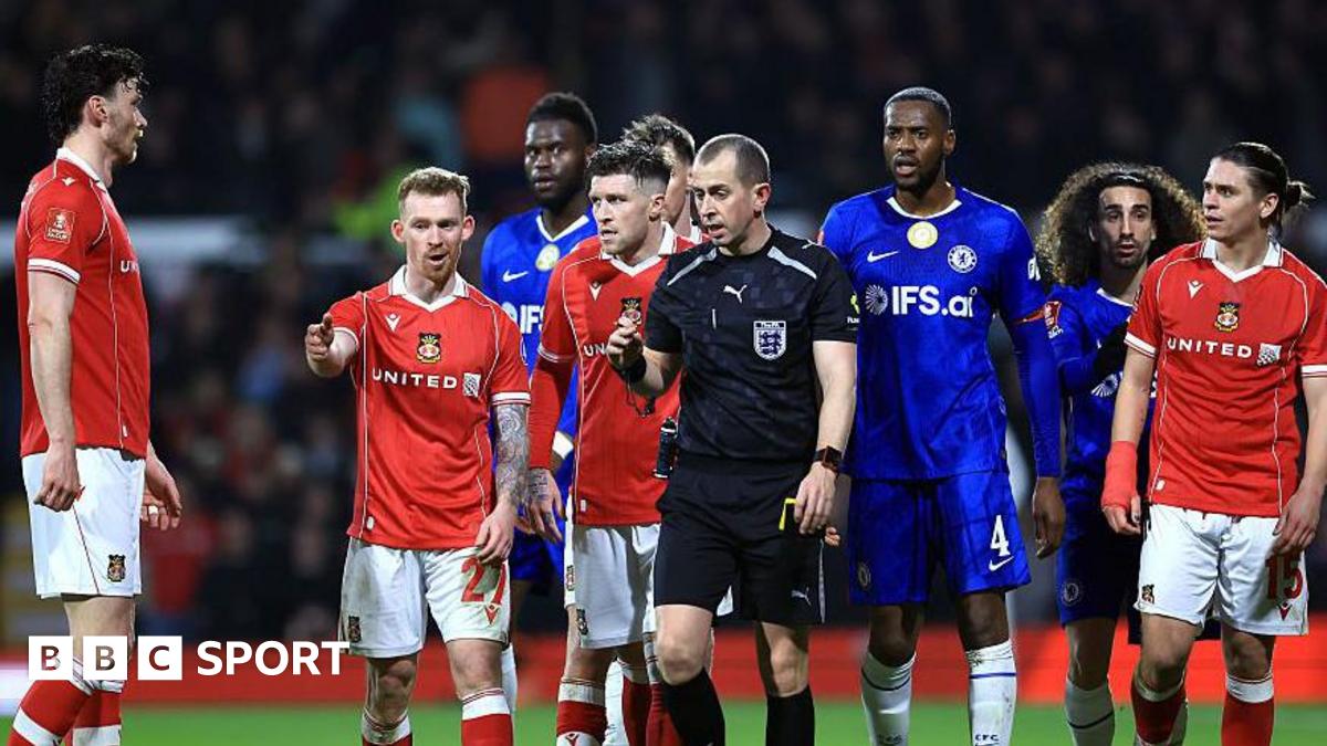 Lewis O'Brien of Wrexham speaks to Referee Peter Bankes as a VAR review takes place