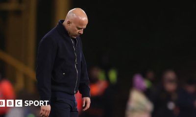 Rob Edwards raises his fists to the air and shouts in celebration, eyes closed