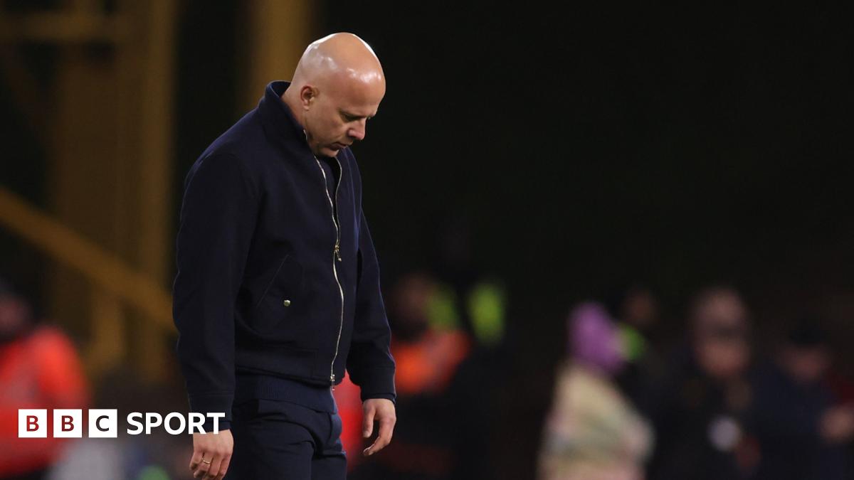 Rob Edwards raises his fists to the air and shouts in celebration, eyes closed