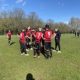 Great Western FC huddled on a sunny football pitch