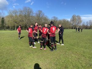 Great Western FC huddled on a sunny football pitch