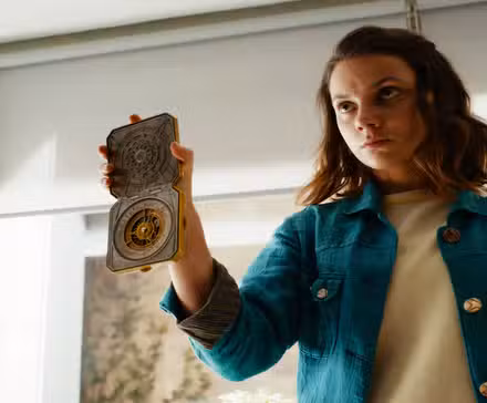 Lyra holding the compass in His Dark Materials.