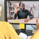 businesswoman waves at a colleague she's meeting with in a Zoom call
