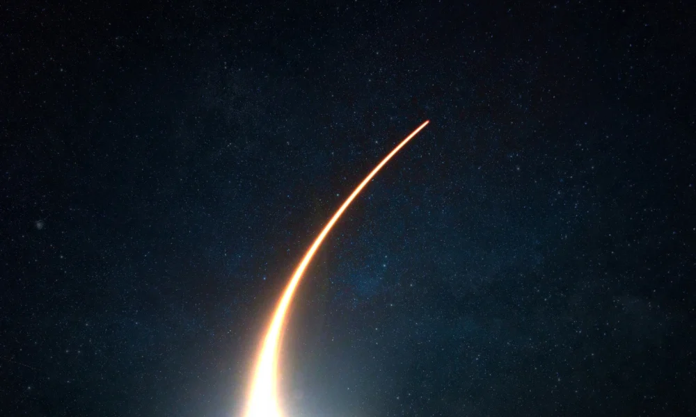 Rocket with a light blast flies and takes off into space in the starry sky. Spaceship launch on a dark background, concept.