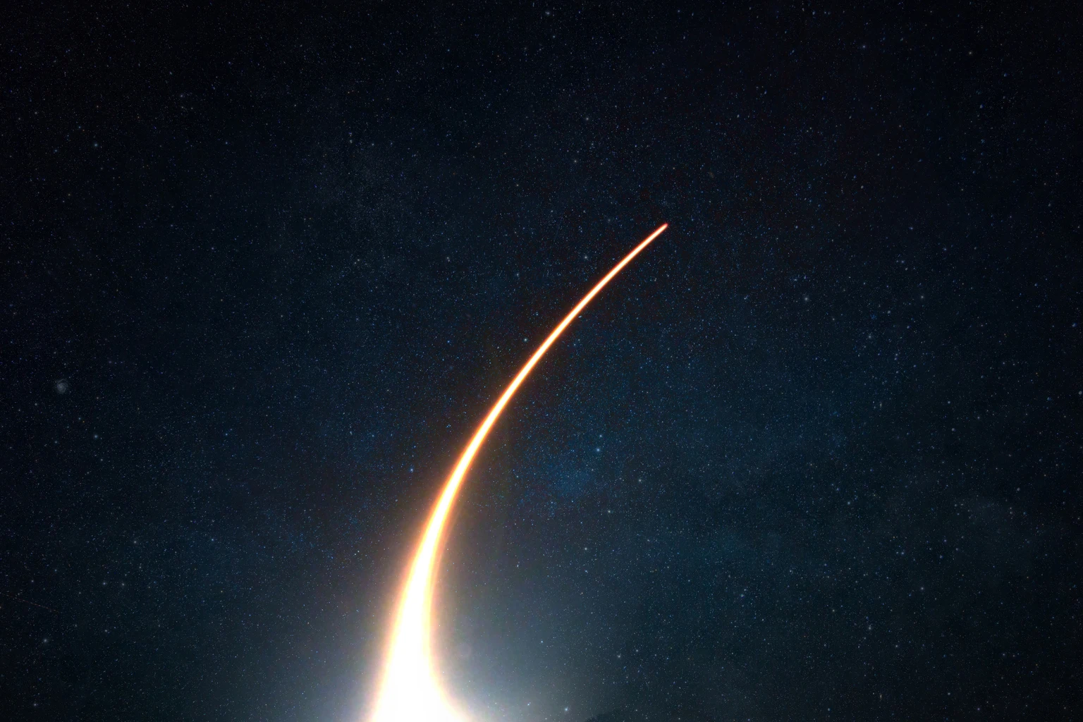 Rocket with a light blast flies and takes off into space in the starry sky. Spaceship launch on a dark background, concept.