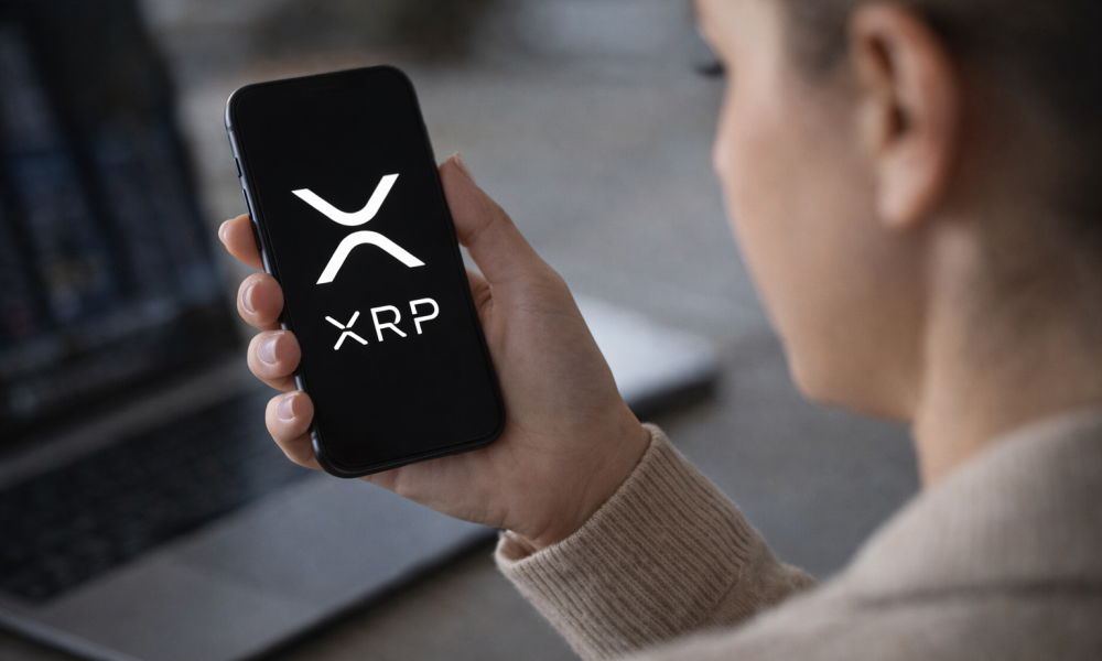 Person holding a smartphone displaying the XRP cryptocurrency logo while checking digital asset markets.