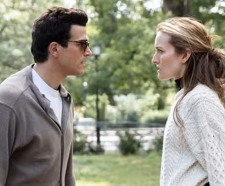 JFK Jr. and Carolyn Bessette facing each other in a park