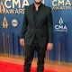 Luke Bryan standing on the CMA red carpet