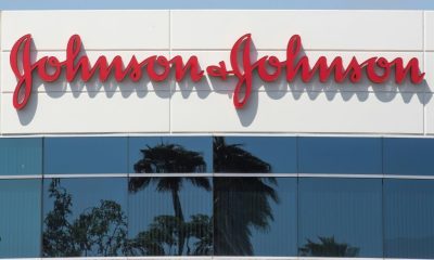 The tech sector led record gains in the S&P 500 index. Pictured: a man with umbrella walks past the New York Stock Exchange.