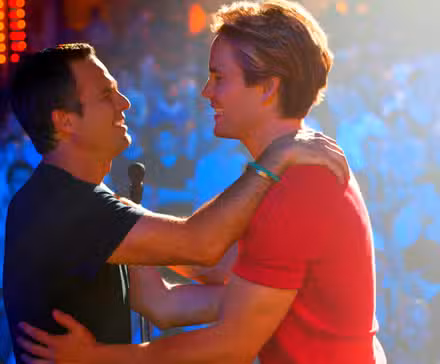 Ned and Felix, played by actors Mark Ruffalo and Matt Bomer, embrace each other on a stage in front of an audience in The Normal Heart.