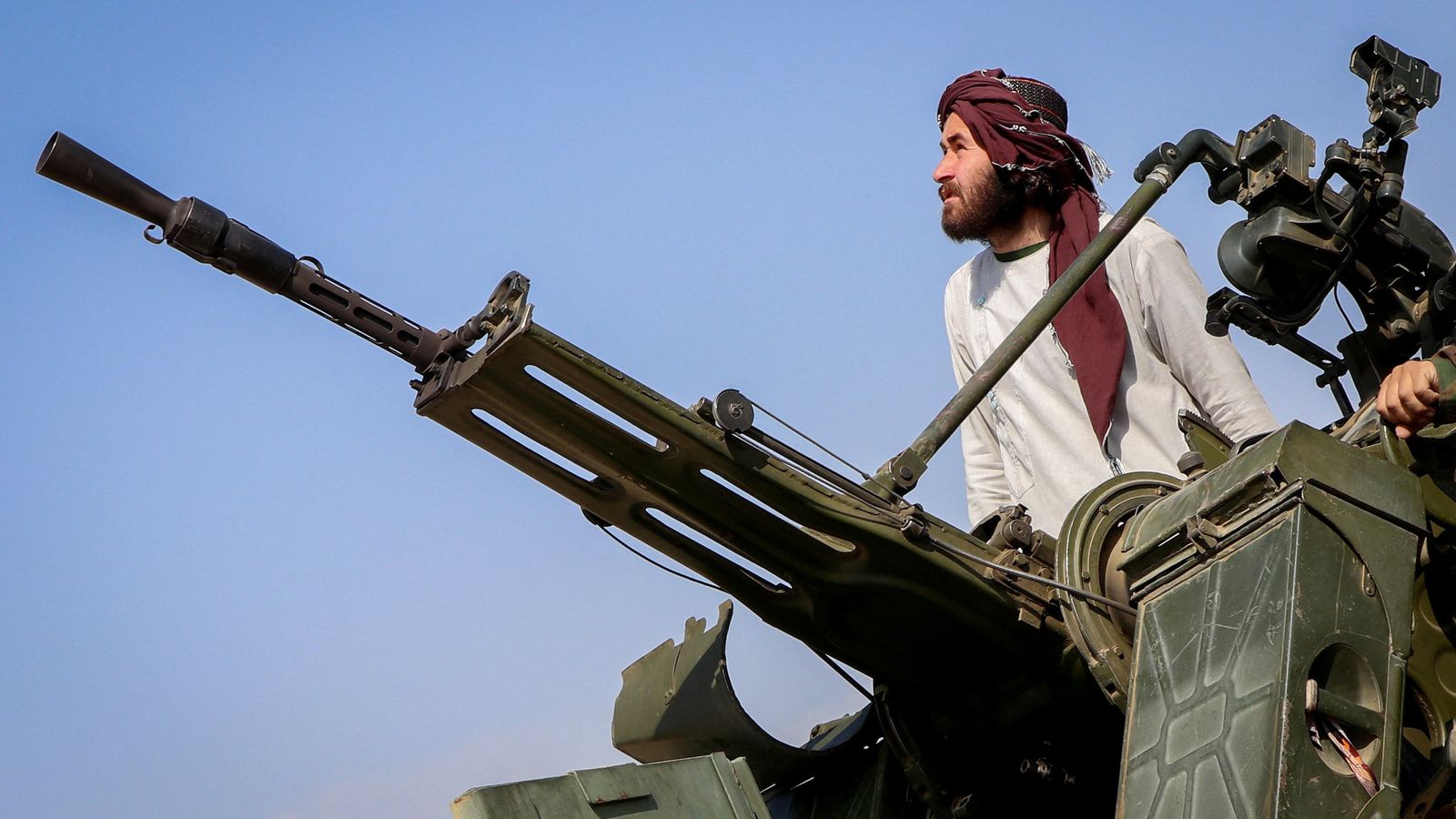 A Taliban fighter stands next to an anti-aircraft gun in Khost province, Afghanistan. Pic: Reuters