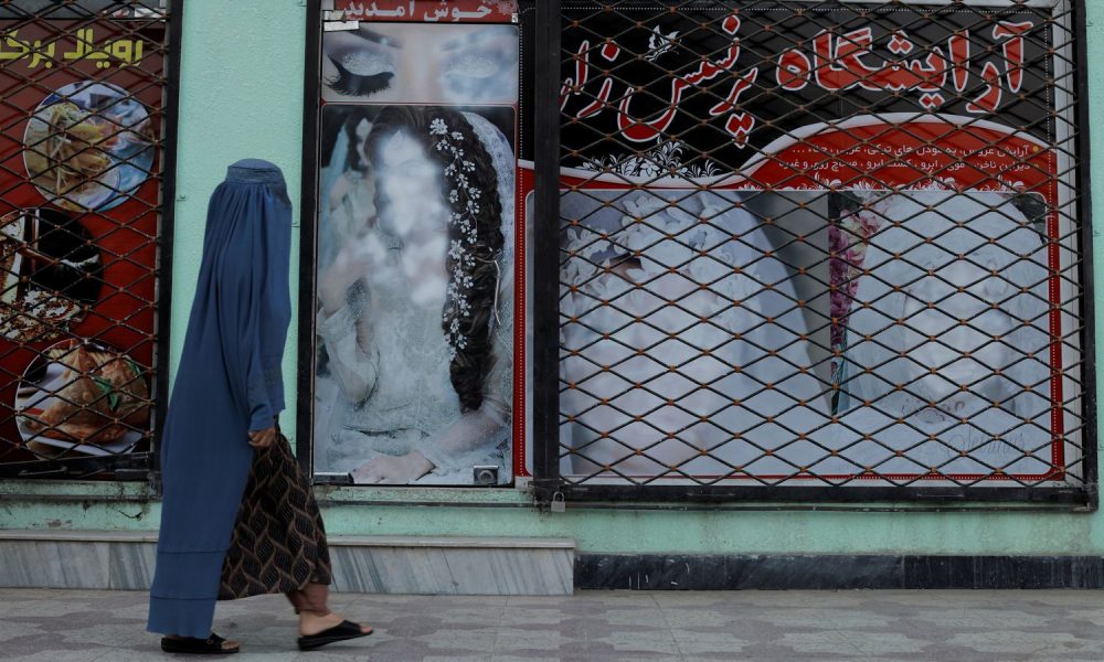 The faces of women on a wall in Kabul have been defaced. Pic: Reuters