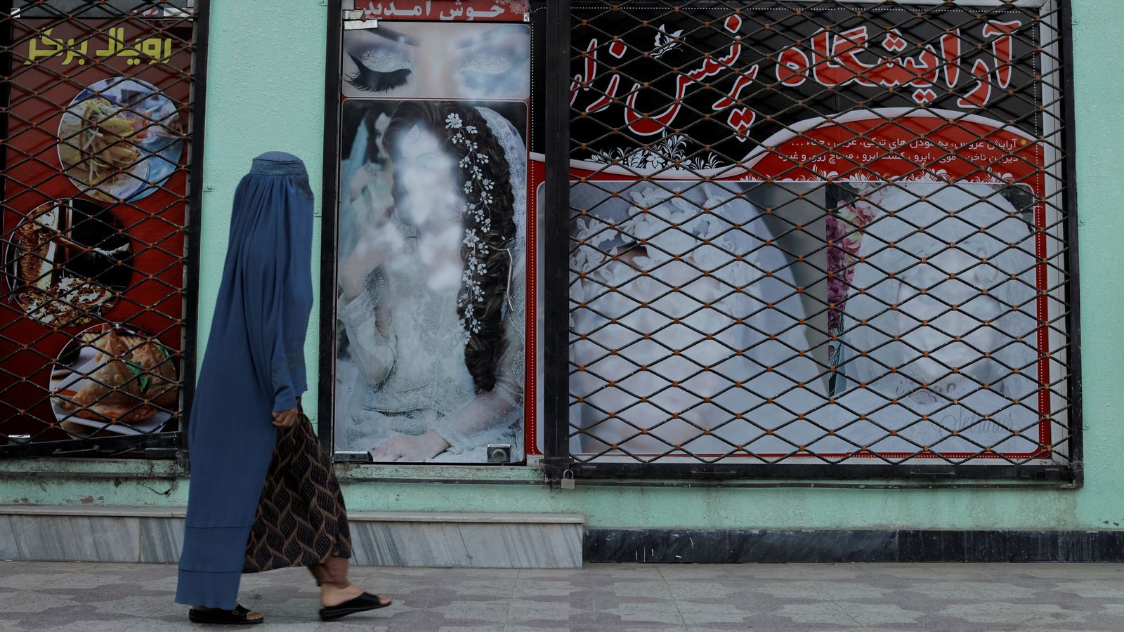The faces of women on a wall in Kabul have been defaced. Pic: Reuters