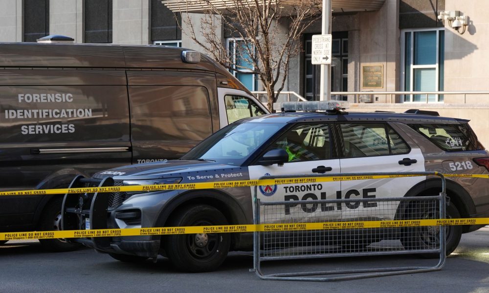 Police vehicles are parked by the US consulate after it was hit by gunfire in Toronto. Pic: AP