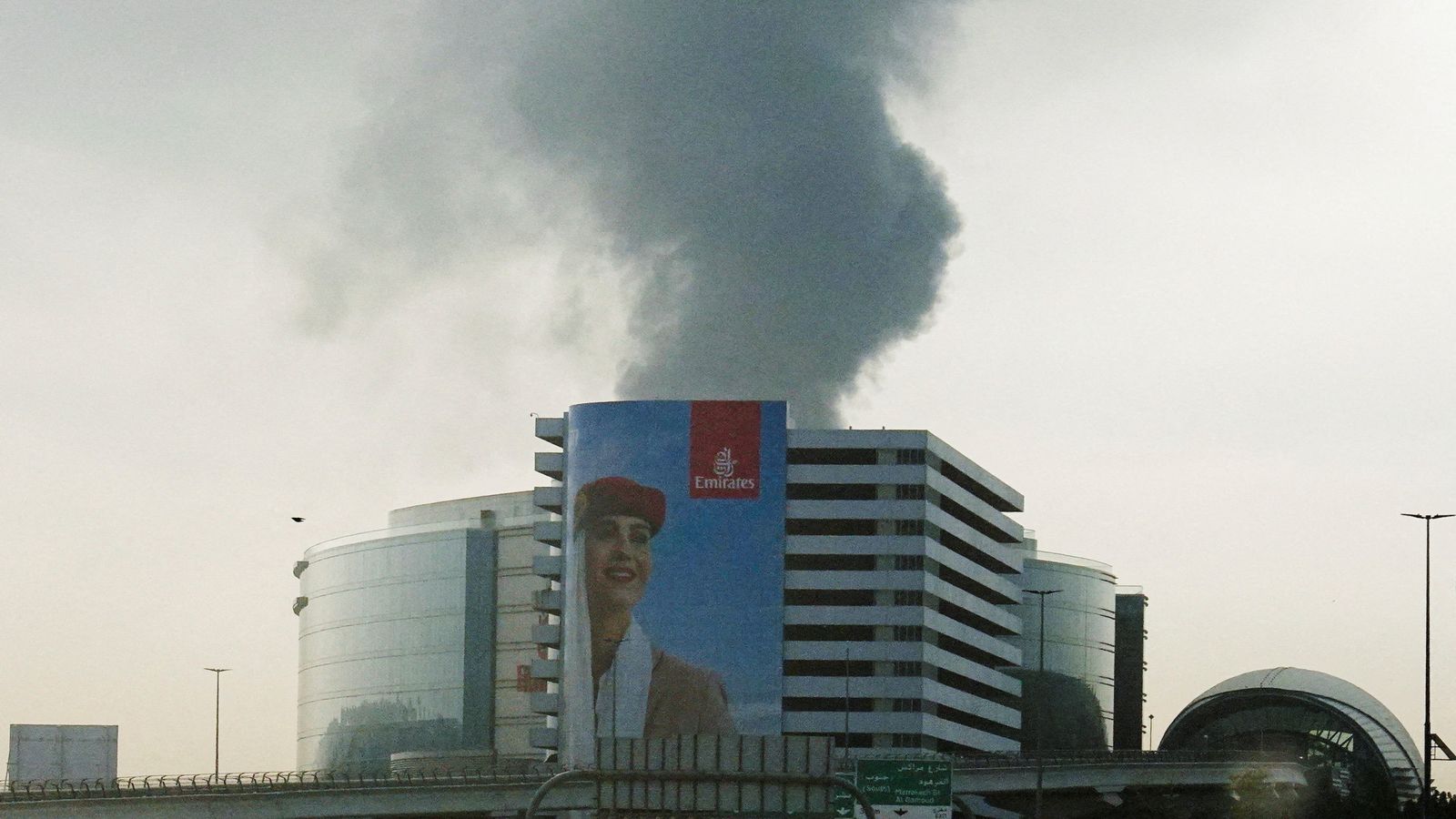 Smoke rising from a burning fuel tank near Dubai International Airport, seen through the windshield of a vehicle. Pic: Reuters