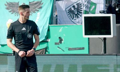 Match referee Felix Bickel stands in front of the blank VAR screen after it was unplugged. Pic: Bernd Thissen/picture-alliance/dpa/AP