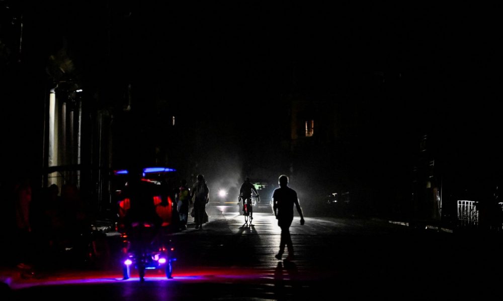 People walk and drive on a street in Havana as Cuba's national electric grid collapsed. Pic: Reuters