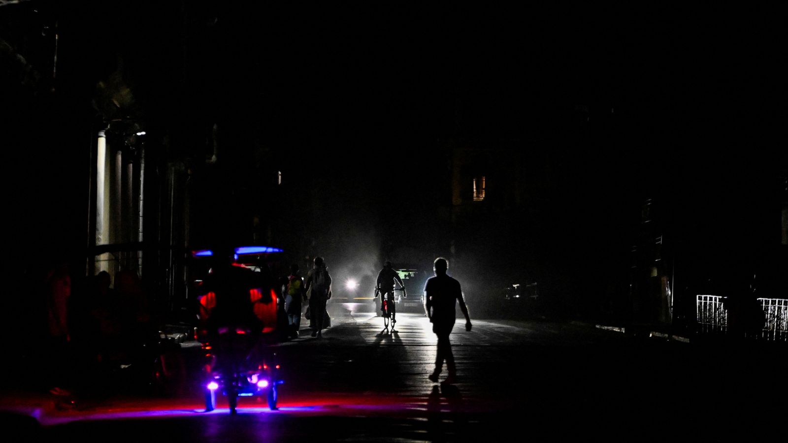 People walk and drive on a street in Havana as Cuba's national electric grid collapsed. Pic: Reuters