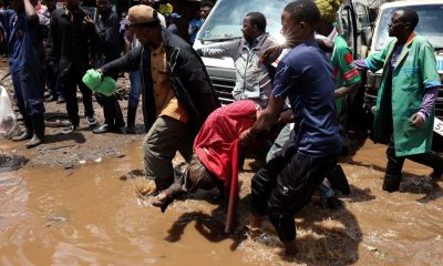 Volunteers carry the body of a person killed by flooding following heavy rainfall in in downtown Nairobi, Kenya. Pic: Reuters