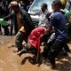 Volunteers carry the body of a person killed by flooding following heavy rainfall in in downtown Nairobi, Kenya. Pic: Reuters