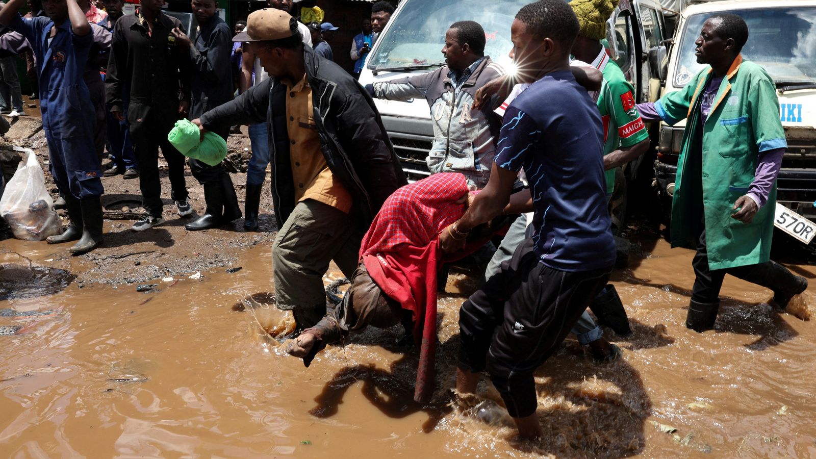 Volunteers carry the body of a person killed by flooding following heavy rainfall in in downtown Nairobi, Kenya. Pic: Reuters