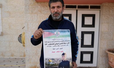 Khalid Ahmad holding a poster of his son, Walid Ahmad, who died in an Israeli prison. Pic: AP