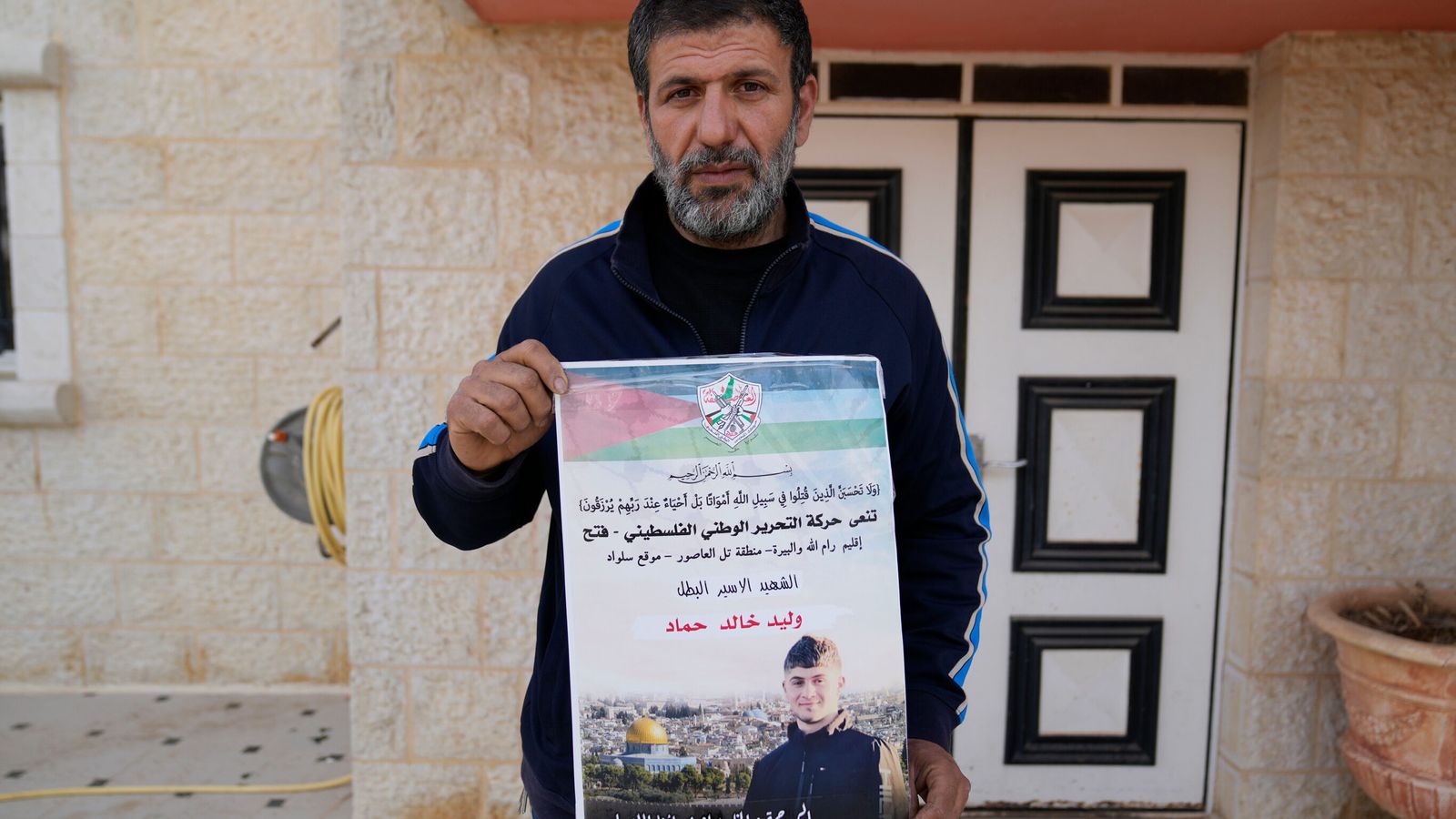 Khalid Ahmad holding a poster of his son, Walid Ahmad, who died in an Israeli prison. Pic: AP