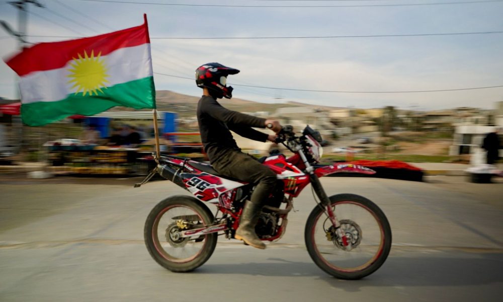 A biker proudly displays a Kurdistan flag